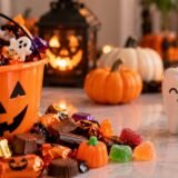 Halloween sweets, chocolates and pumpkins displayed alongside toothbrushes to promote dental care.